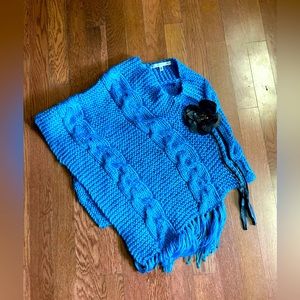 Max Studio cable knit fringed blue poncho with brown leather flower appliqué.EUC